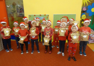 Grupa dzieci trzyma w ręku paczki z prezentami.